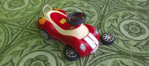 A red toy car that needs to be fixed